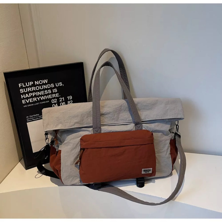 Tote bag in light gray and rust orange with two top handles and a crossbody strap.
