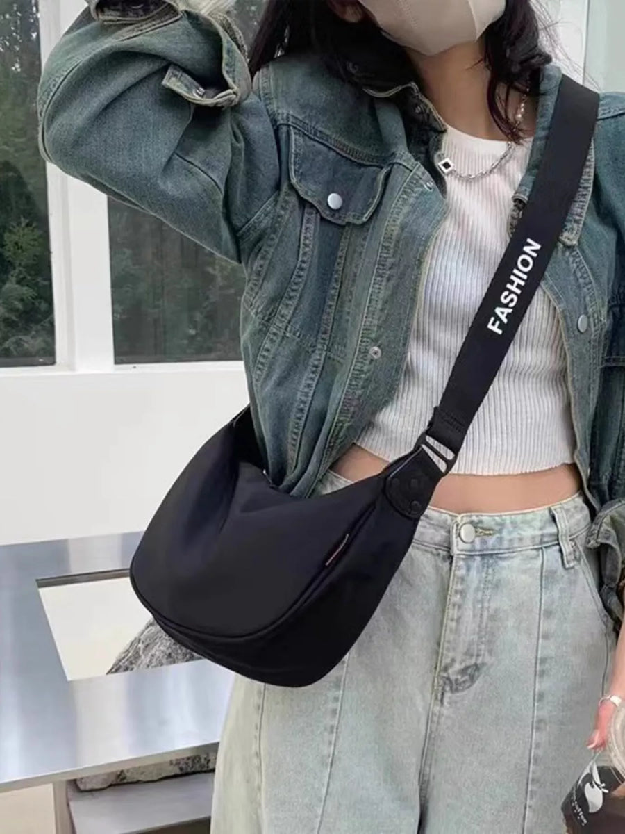 Black crossbody bag with adjustable strap featuring white "FASHION" text.
