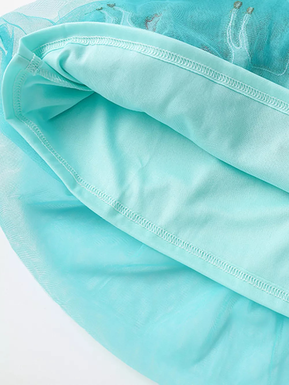 Aqua tulle baby dress with unicorn embroidery detail and cotton lining.