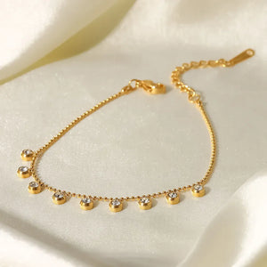Gold-plated necklace with delicate chain and dangling pavé charms.
