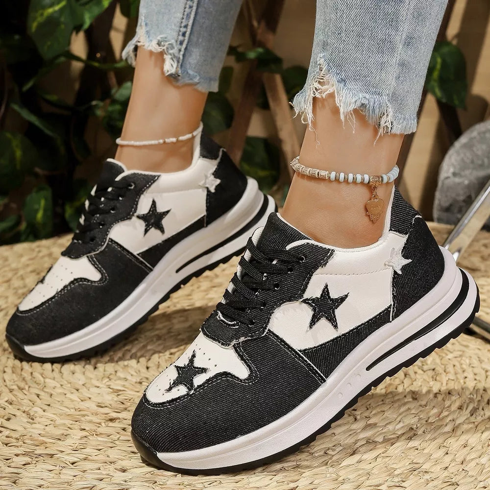 Black and white lace-up sneakers with star embellishments and a chunky sole.