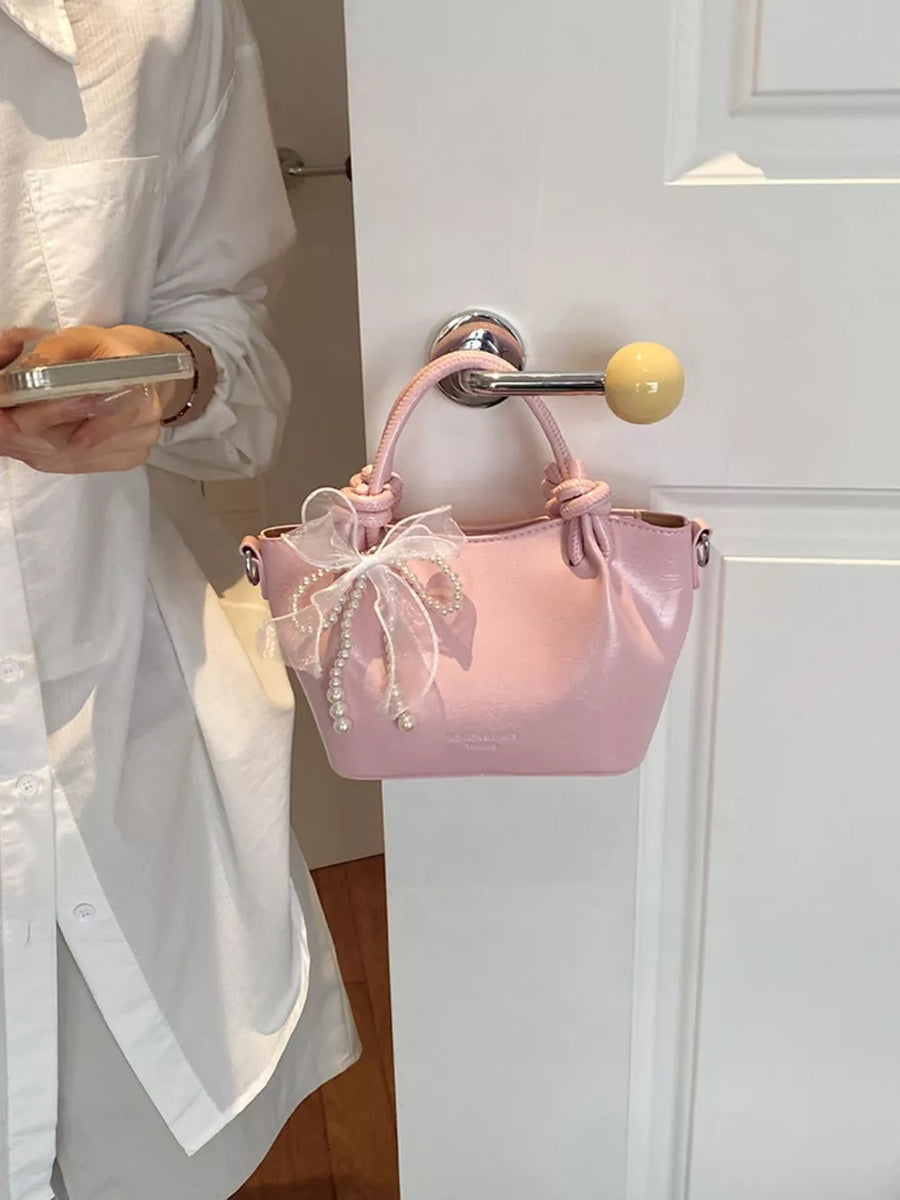 crossbody bag in light pink featuring bowknot and structured fit