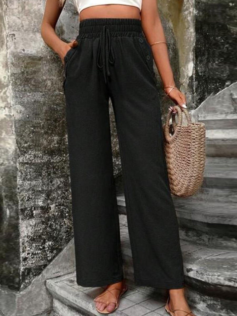 Black linen palazzo trousers with drawstring waist and side buttons.
