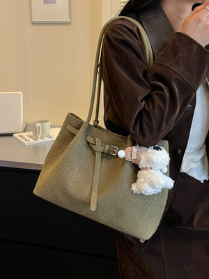 Green shoulder bag featuring woven texture and geometric