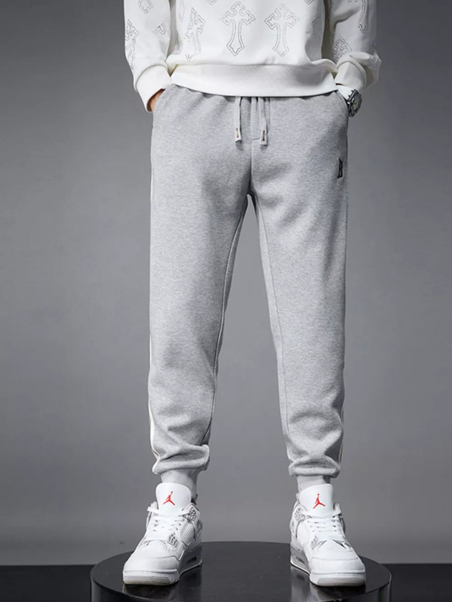 Light gray cotton joggers with drawstring and cuffed hem.
