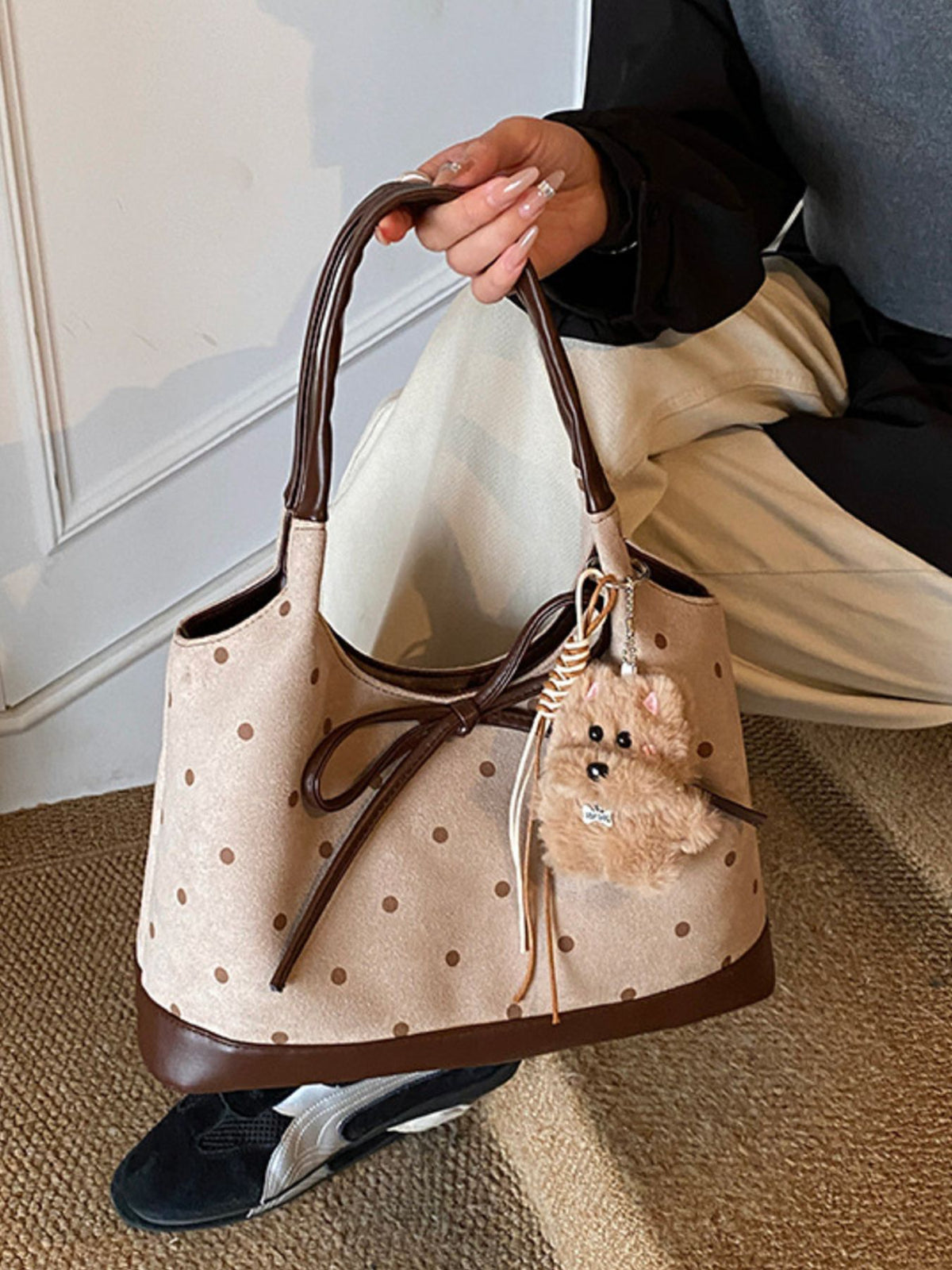 brown handbag featuring bow detail and polka dot