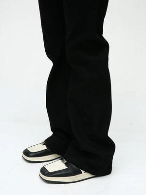 Flared leg denim trousers in dark black, styled with two-tone shoes.
