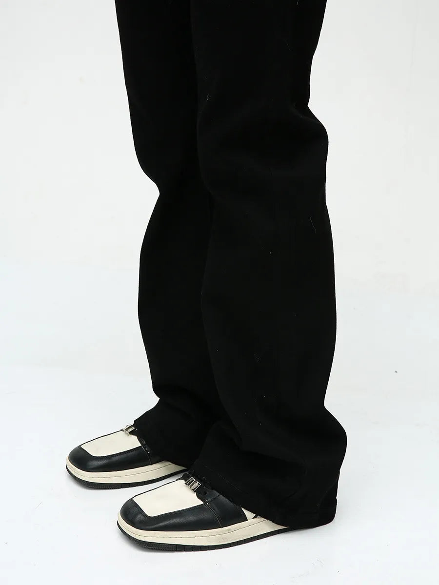Flared leg denim trousers in dark black, styled with two-tone shoes.