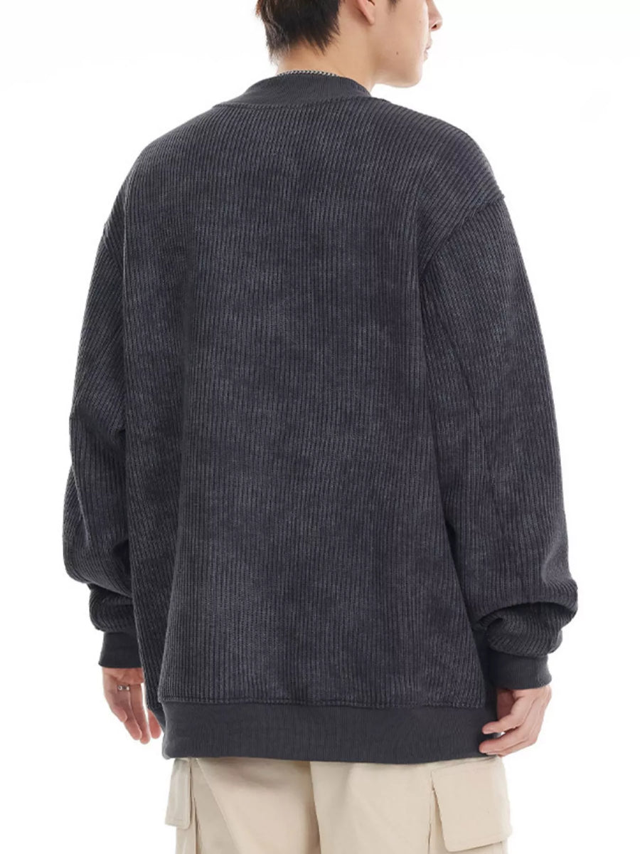 Dark gray oversized corduroy sweatshirt with round neck and ribbed cuffs and hem.