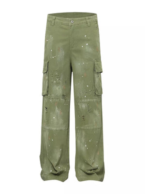 Green distressed cargo pants with paint splatters and ripped accents