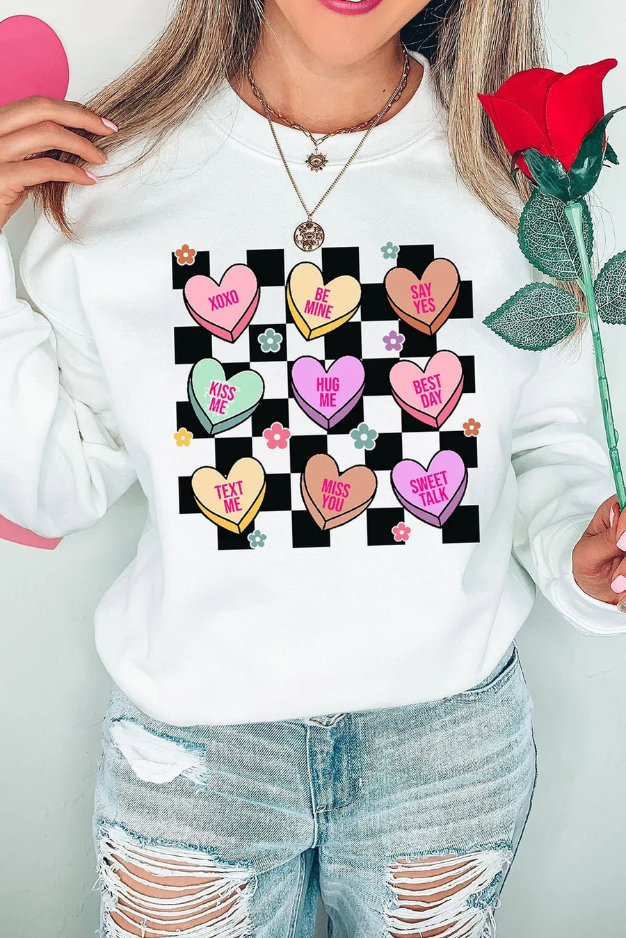 White sweatshirt with conversation heart graphic and checkered background
