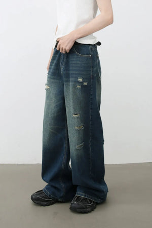 Distressed baggy denim jeans in dark wash with ripped details.