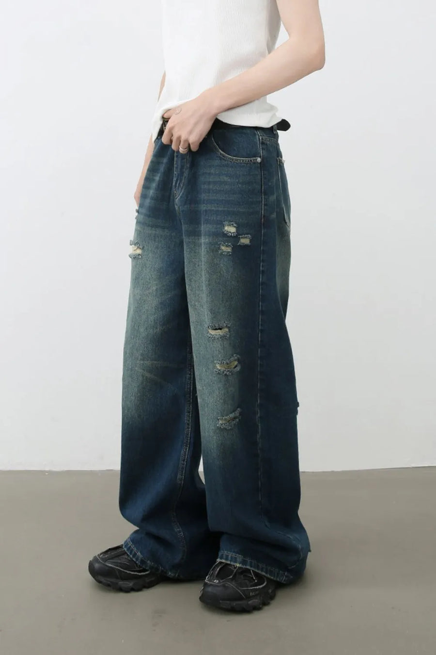 Distressed baggy denim jeans in dark wash with ripped details.