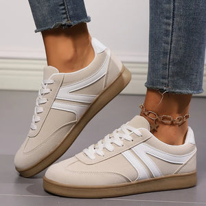 Beige suede sneakers with white chevron detail and gum sole.