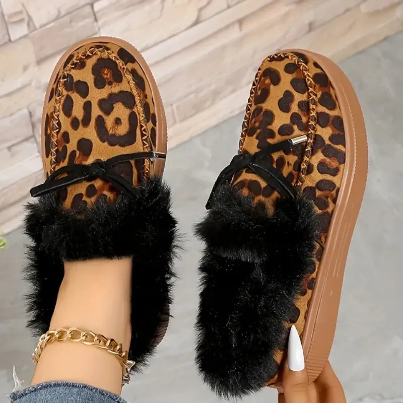 Leopard print loafers with black shearling trim and bow detail.