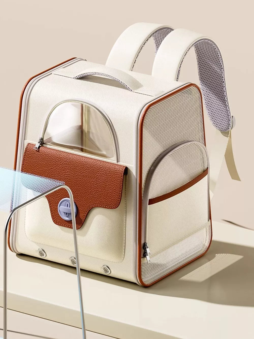 Chic two-tone cream and brown pet carrier backpack with mesh windows and leather flap pocket.