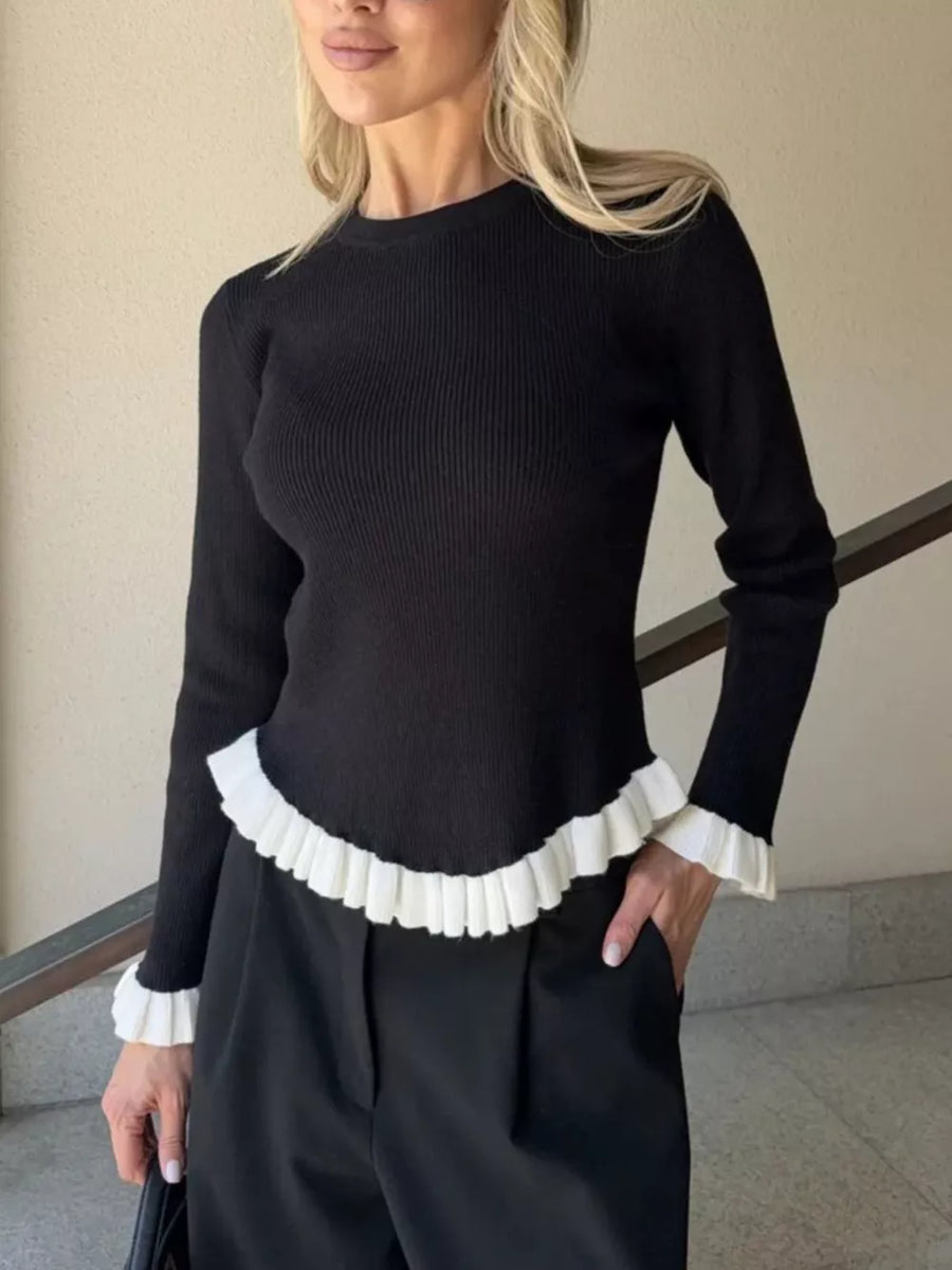 Black ribbed knit sweater with contrast white ruffled hem and cuffs
