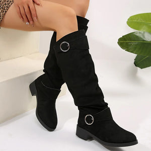 Black slouchy knee-high boots with buckle detail and block heel.