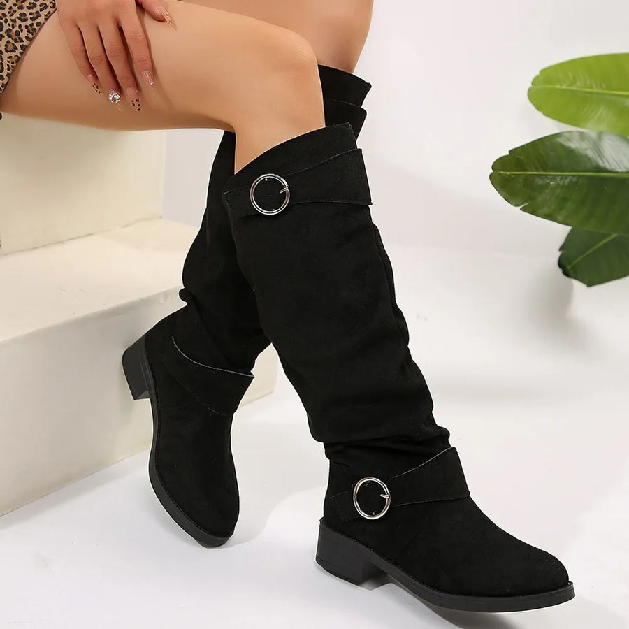 Black slouchy knee-high boots with buckle detail and block heel.