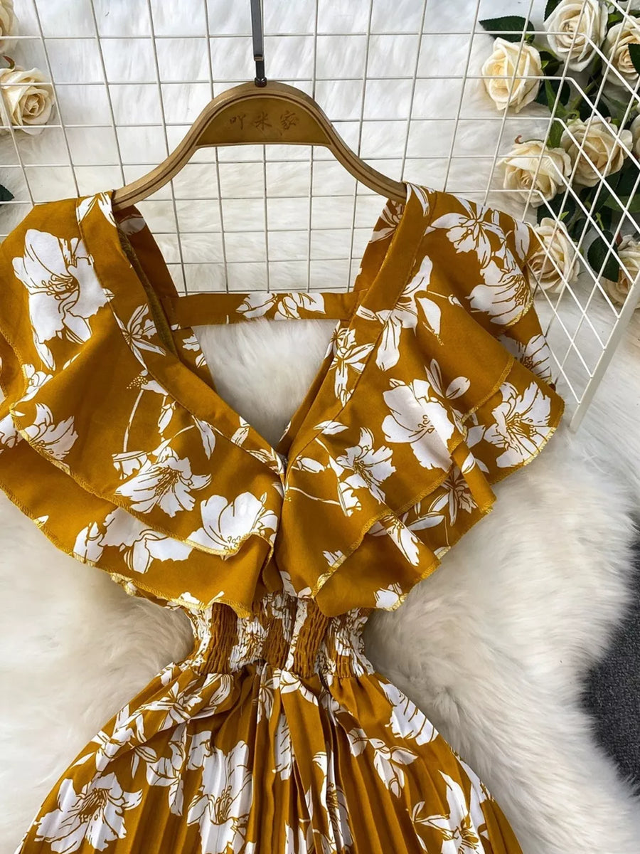 Yellow floral print cotton romper with ruffled sleeves and smocked waist.