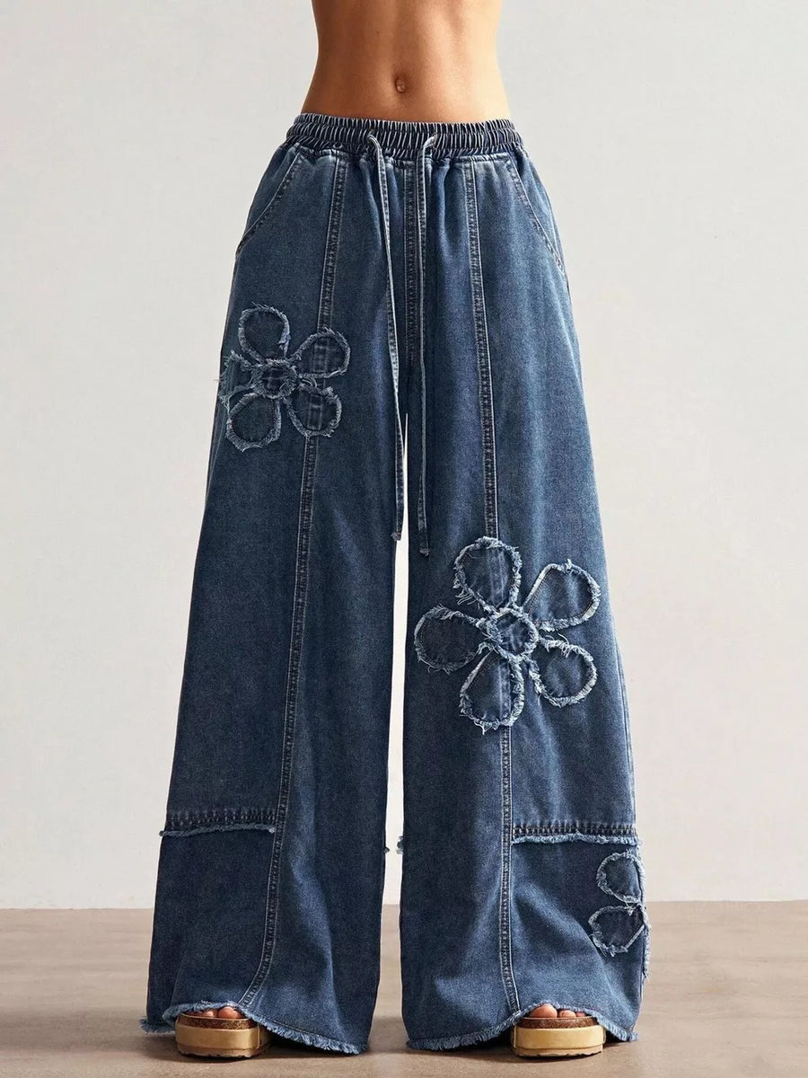 Wide leg denim jeans in blue with floral appliques and drawstring waist