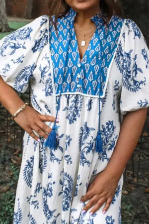 Maternity midi dress with blue floral print, puff sleeves, V-neck, and tassel details.