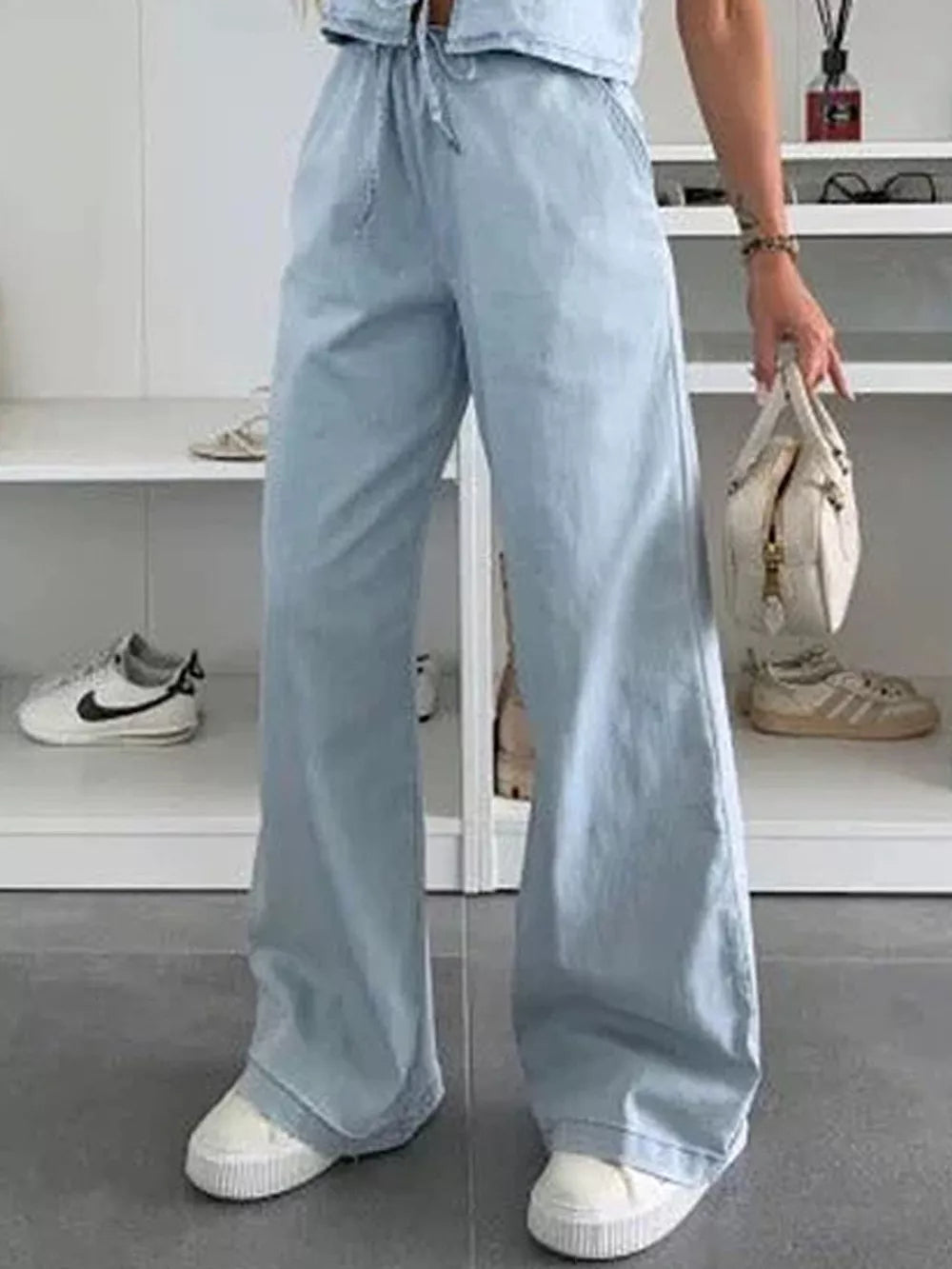 Light blue denim wide-leg pants with drawstring waist and relaxed fit.