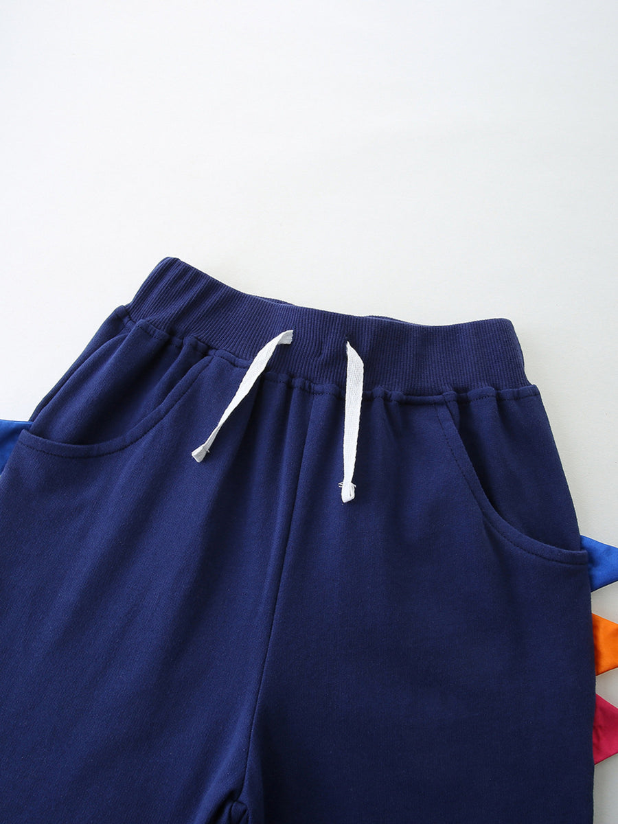 Navy blue cotton baby shorts with drawstring and colorful dinosaur spikes detail.