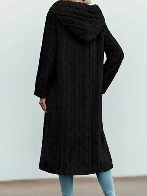 Black hooded longline button up outerwear with cable knit texture and flowing hem.