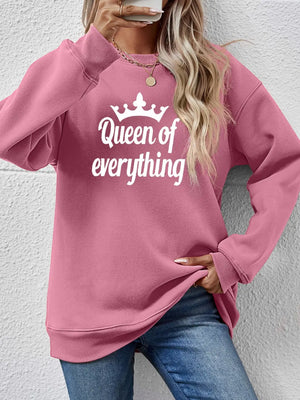 Blush pink graphic sweatshirt with "Queen of Everything" text and crown detail.