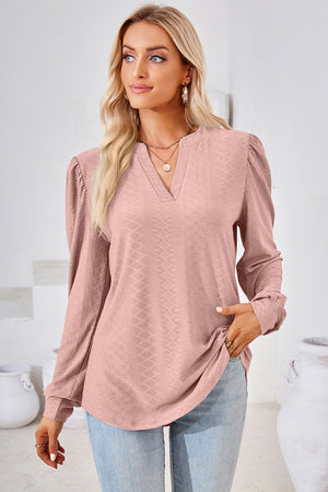 Blush pink textured henley blouse with puff sleeves and a V-neckline