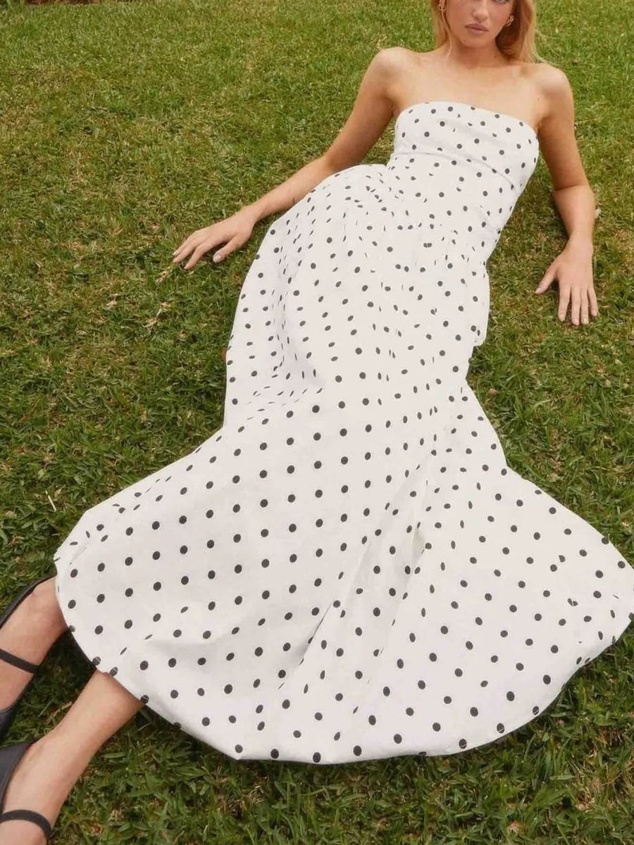 White polka dot strapless maxi dress with a sweetheart neckline and full skirt.