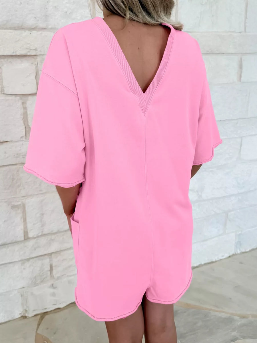 Pink cotton romper with pockets, V-neck, and half sleeves.