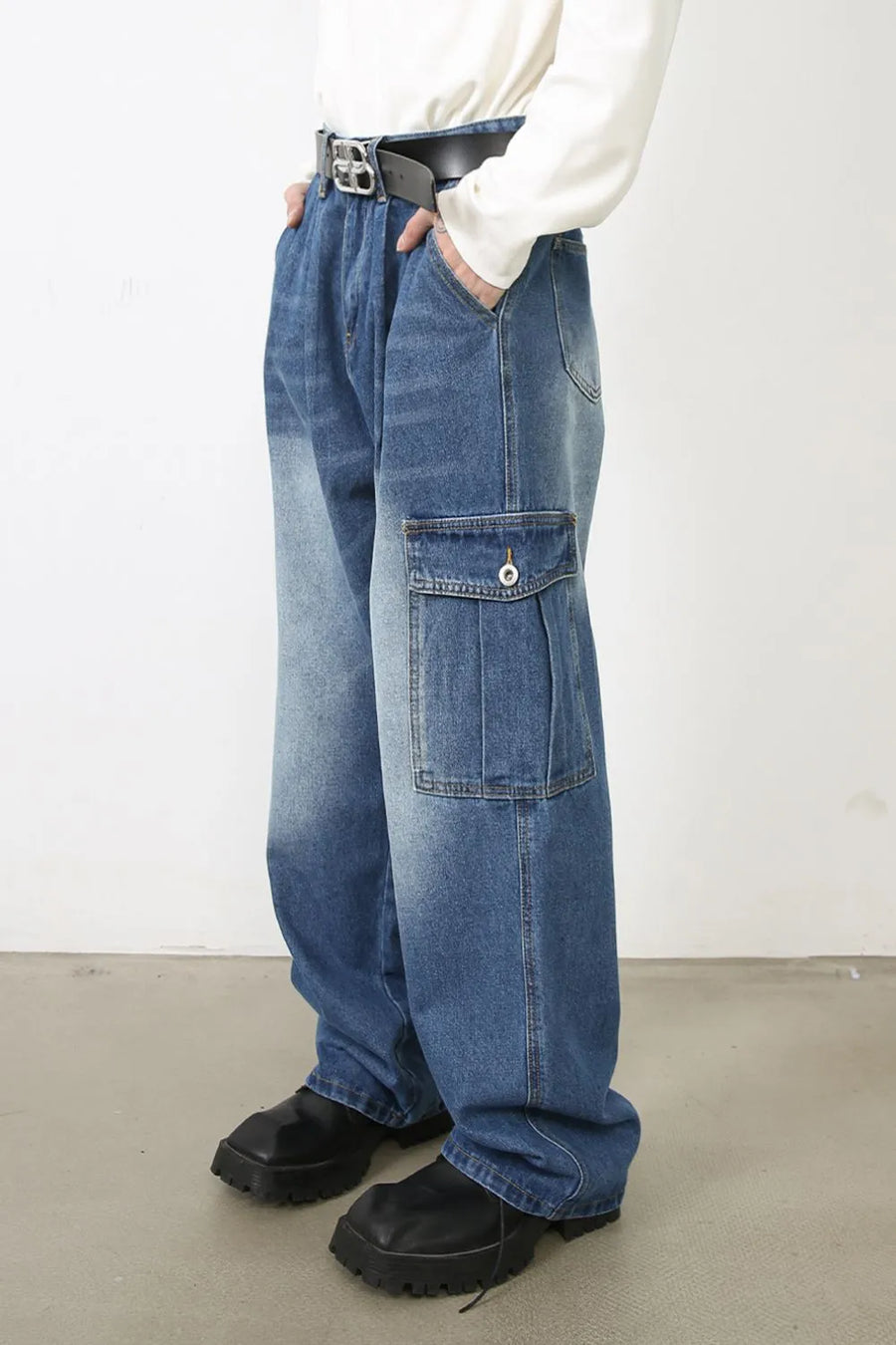 Faded denim cargo pants in medium wash with pleated cargo pockets and a relaxed fit.