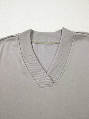Gray v-neck sweatshirt with ribbed collar and cuffs, featuring subtle Aztec embroidery detail.