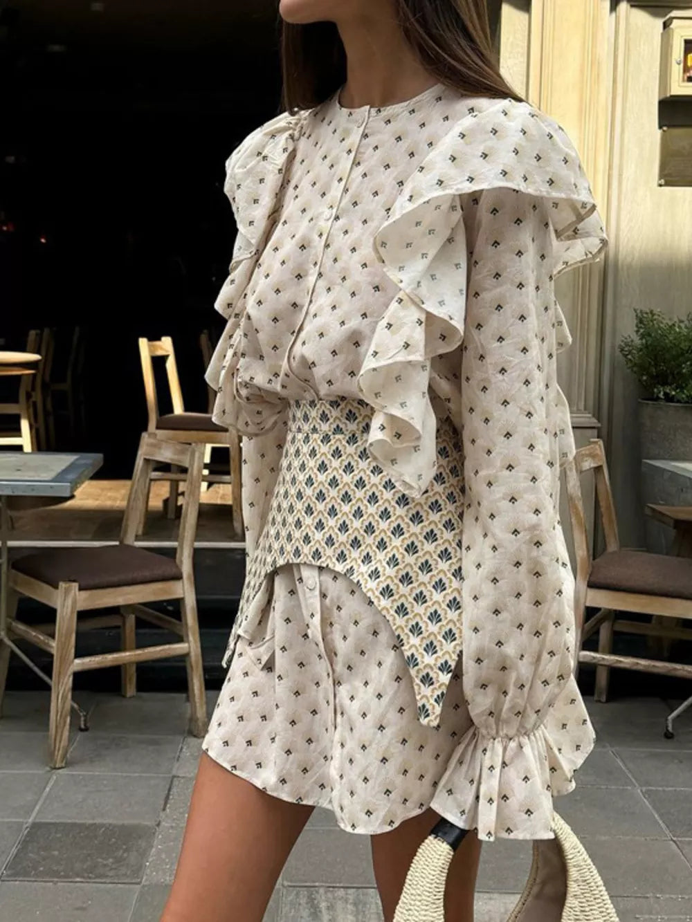 Cream printed mini dress with ruffled sleeves and a patterned vest.