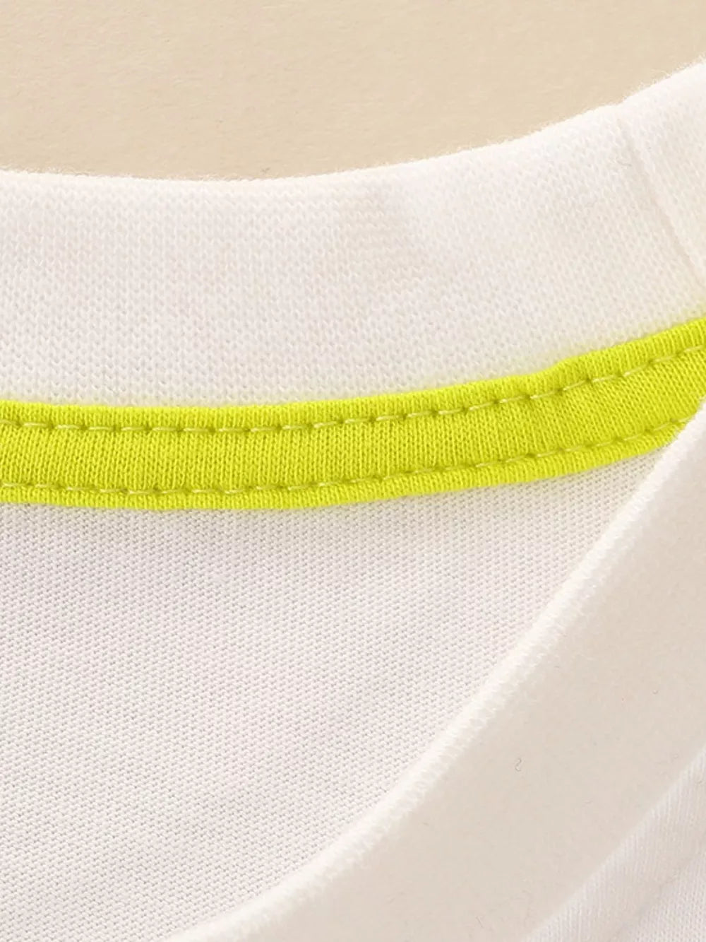 White cotton toddler t-shirt with bright lime green neckline trim.