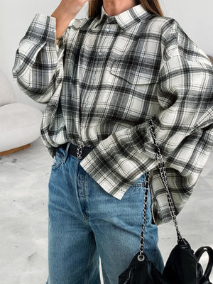 Button-up long sleeve cotton shirt in black and white plaid with two chest pockets.