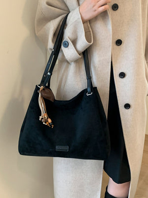 shoulder bag in black featuring tassel charm and unstructured fit