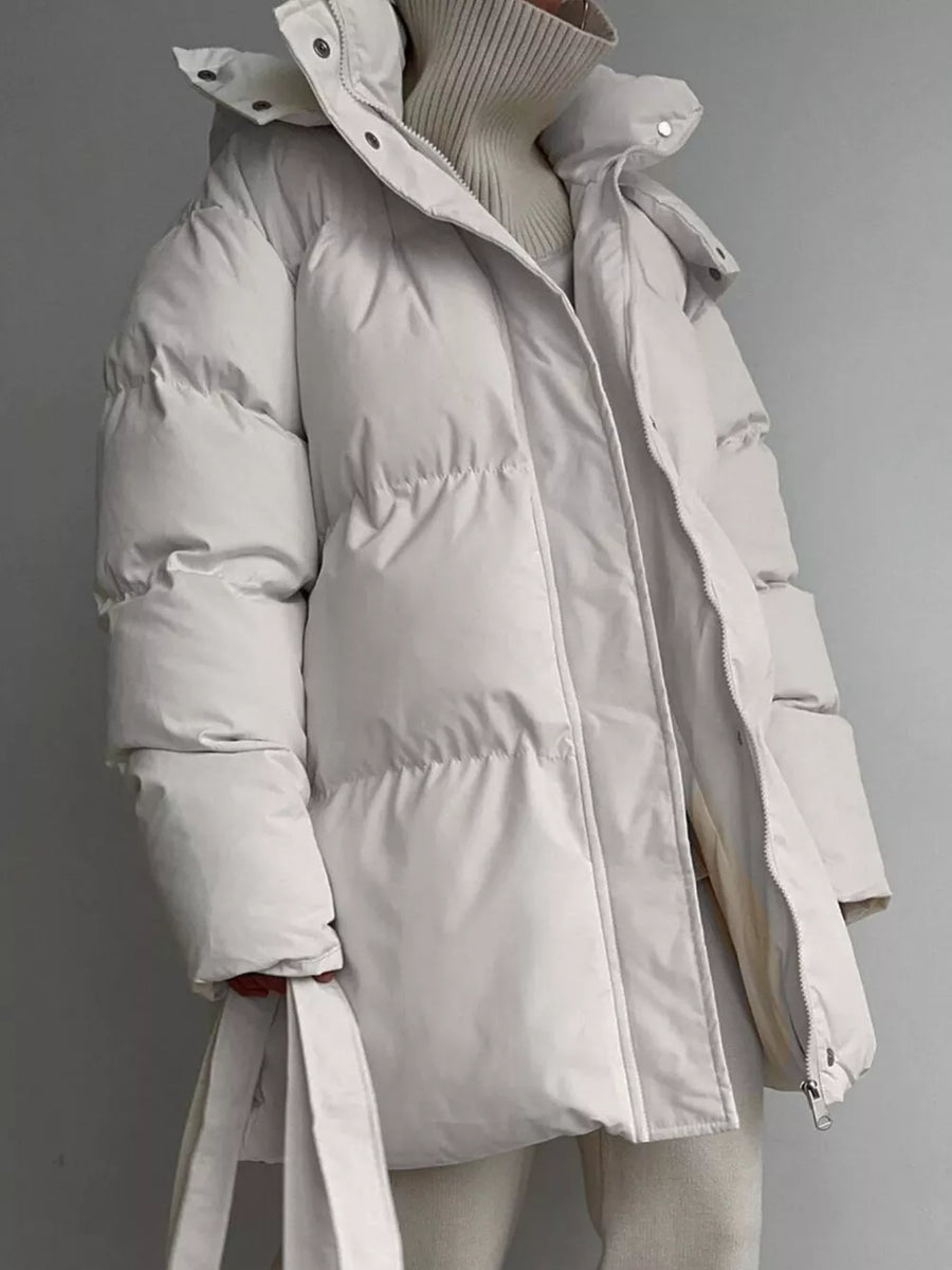 Ivory white puffer trench coat with hood and belt, featuring a zip and button closure.