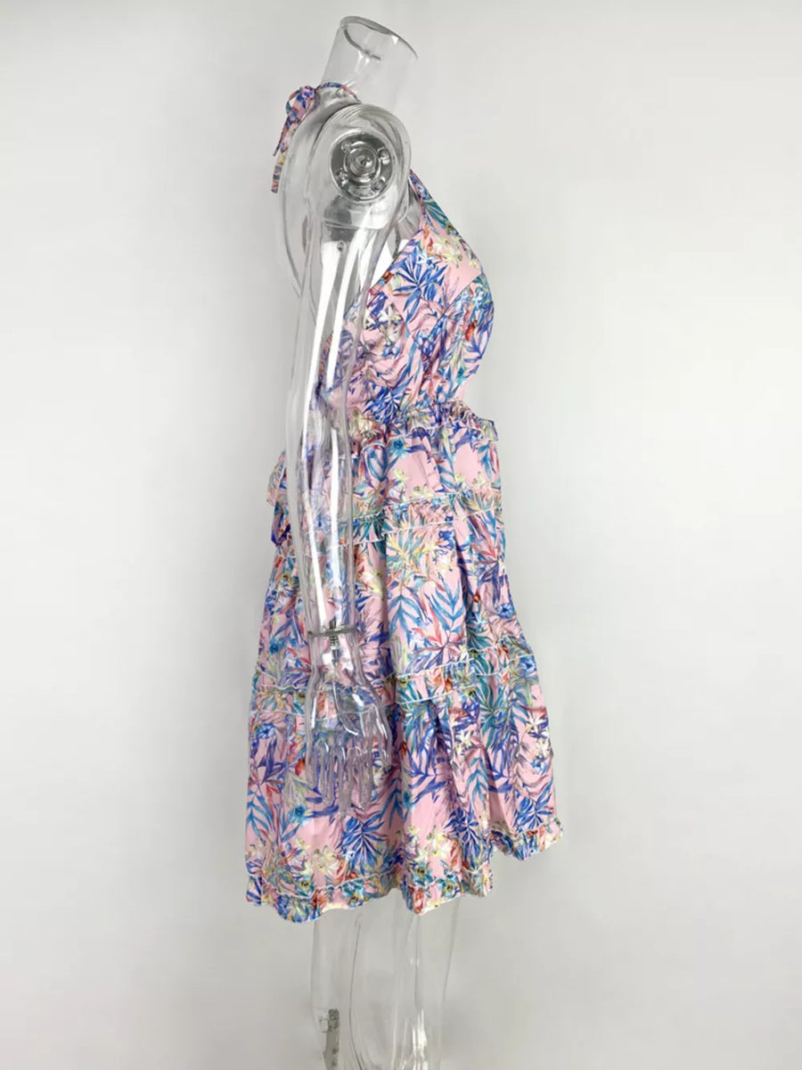Halter mini dress in pink with abstract blue and green leaf print, cutout sides, tiered skirt.