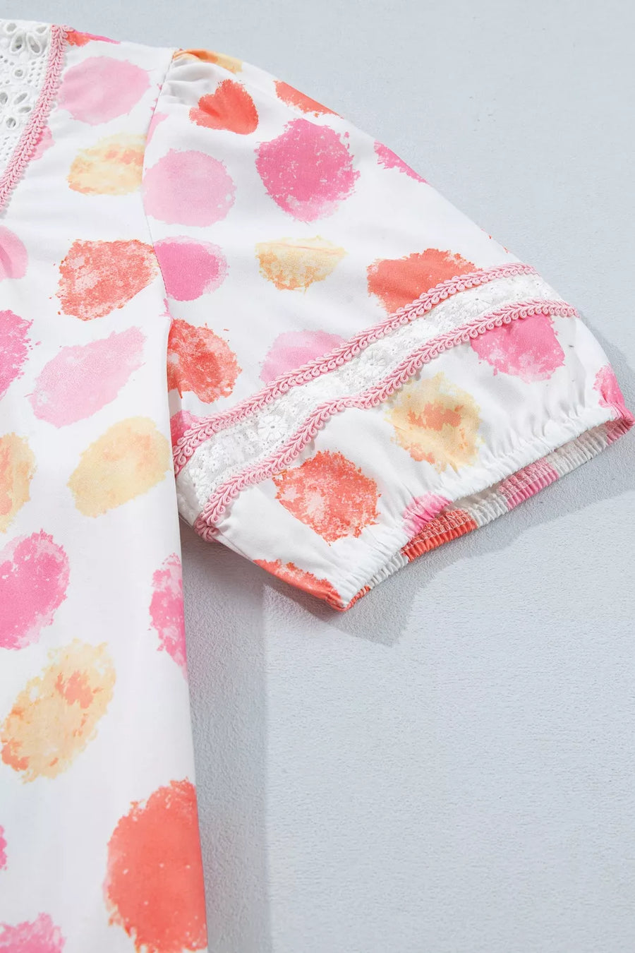 White polyester blouse with pink, orange, and yellow watercolor dots, puff sleeves, and lace trim.
