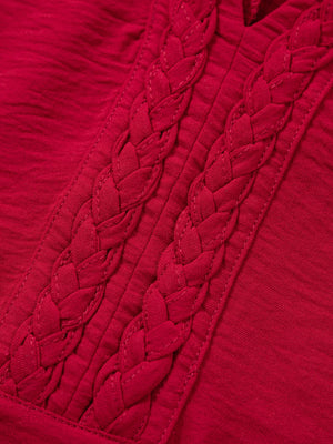 Deep red braided V-neck blouse with textured fabric and braided neckline detail.