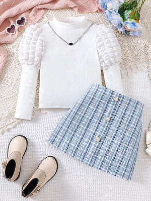 Baby girls' white puff sleeve top and blue plaid skirt set with pearl buttons.