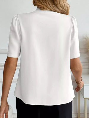 White short sleeve puff sleeve shirt with a V-neck and button detail.