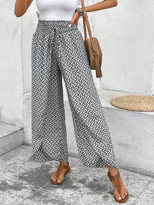 Palazzo pants with a black and white geometric print, elastic waist, and drawstring.