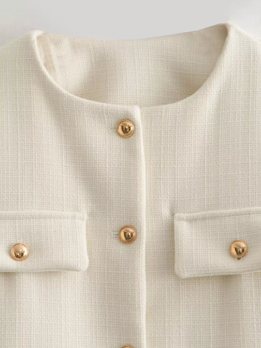 White tweed cropped jacket with gold button details and pocket flaps.