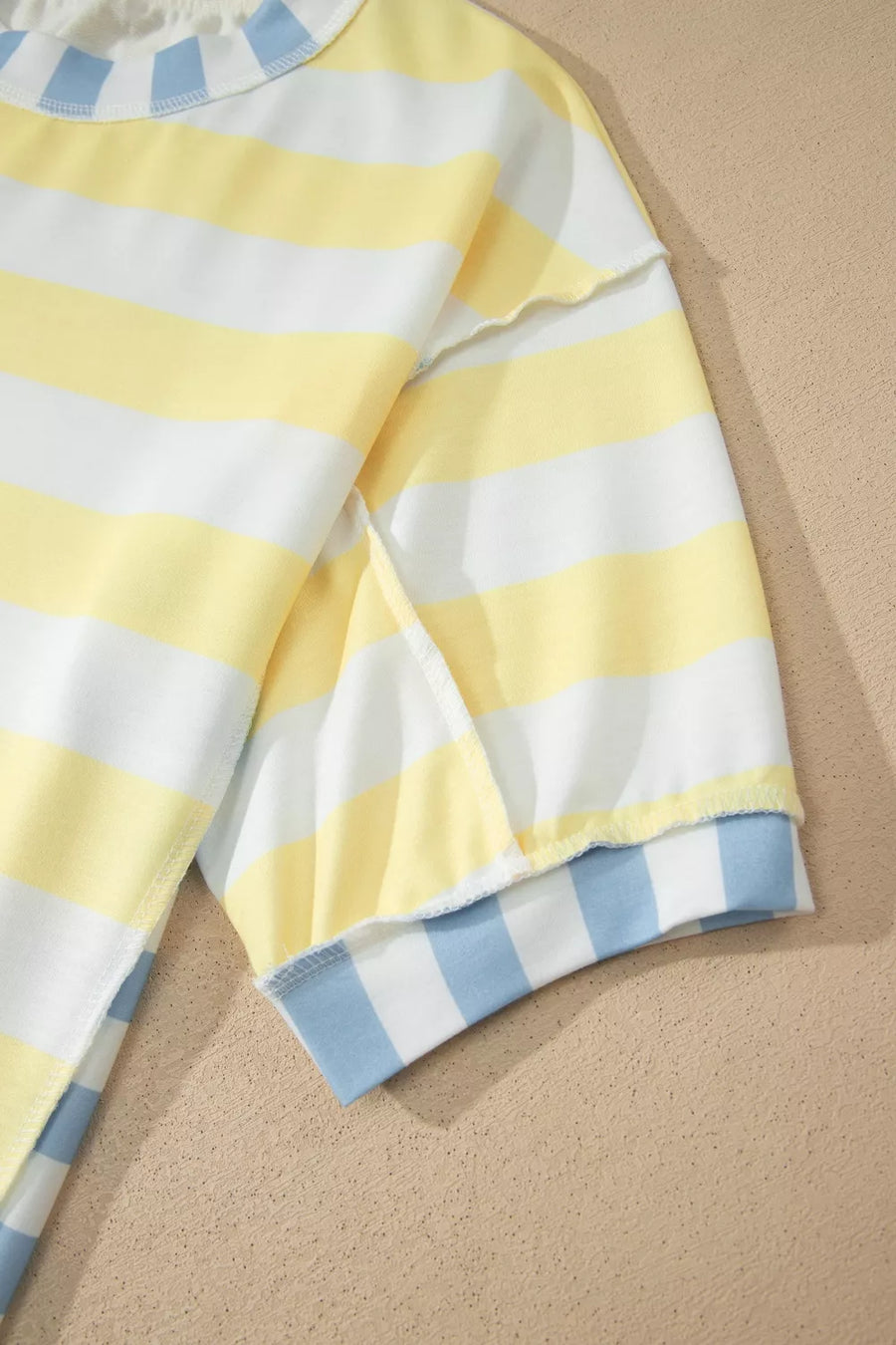 Striped t-shirt with yellow, white, and blue stripes, crew neck, short sleeves.