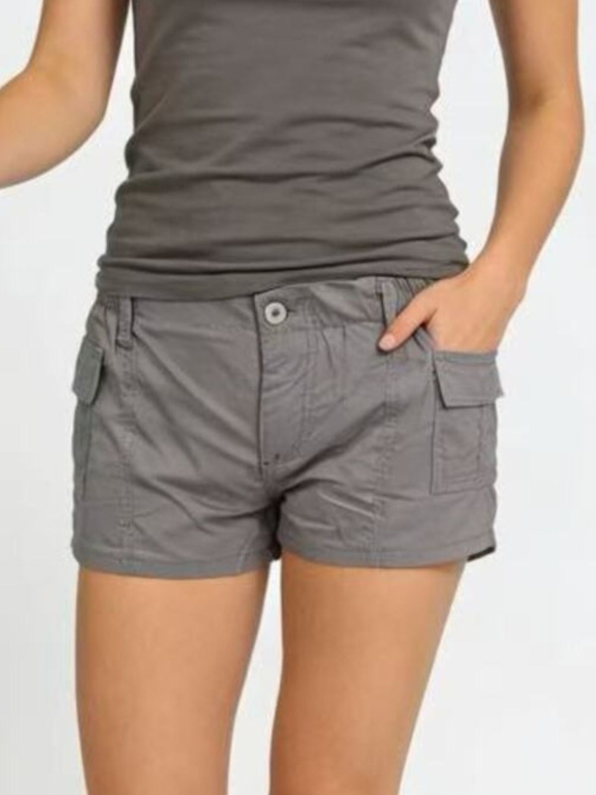 Gray cargo shorts with button closure and side pockets, styled with a tank top.