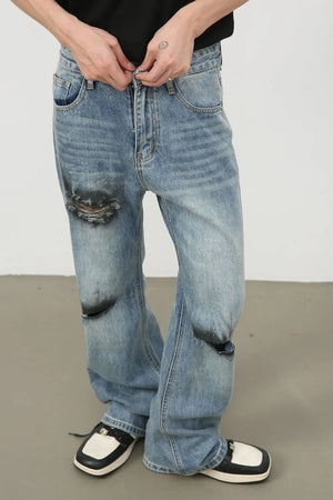 Distressed flare leg jeans in medium wash denim with ripped knee details.
